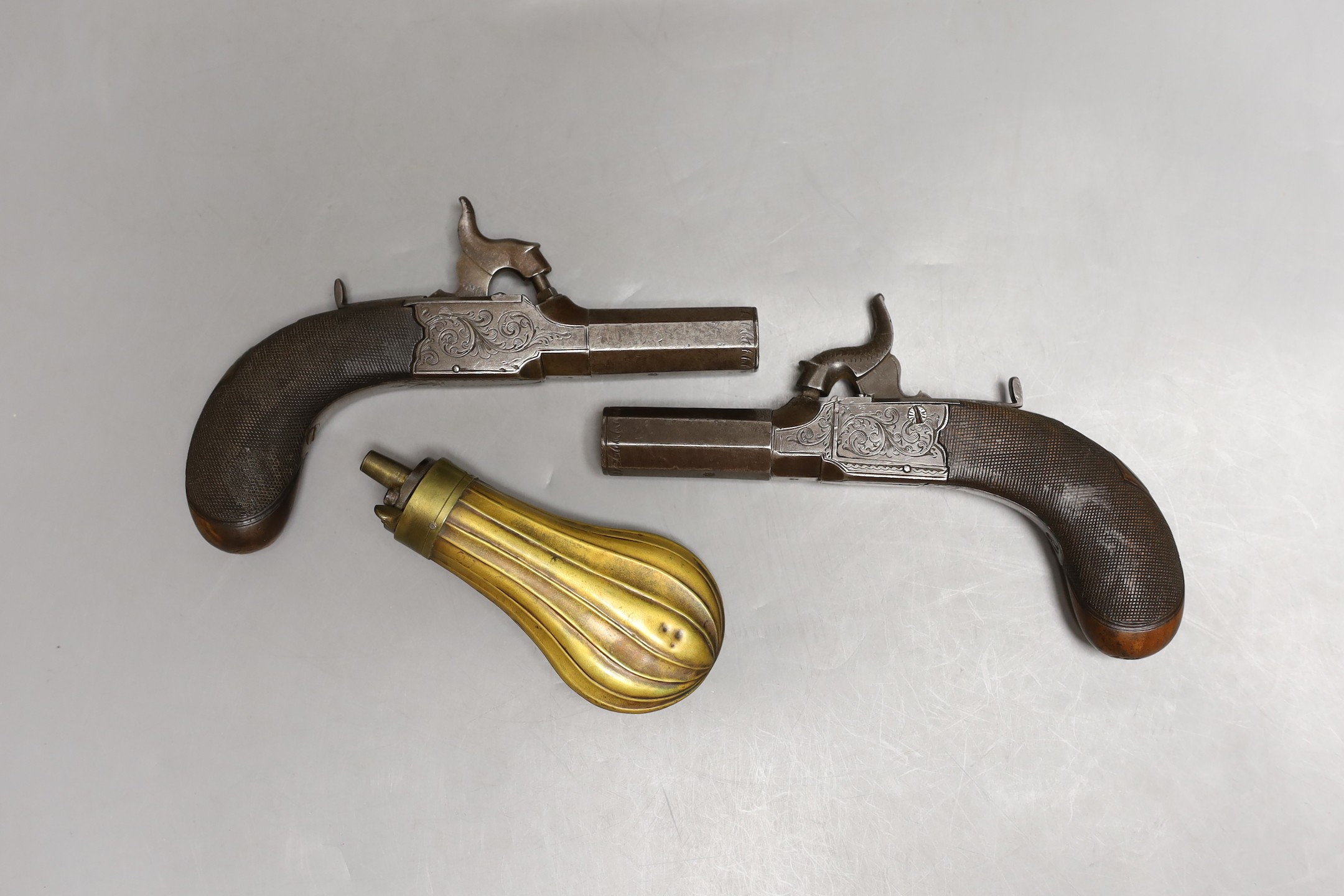 A pair of muff pistols and powder flask, original fitted mahogany case and key, circa 1830